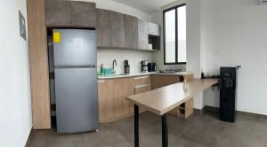 a kitchen with a refrigerator and a table in it at FinlandHouse in Puerto López