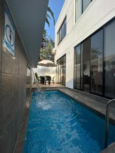 a swimming pool in front of a building at FinlandHouse in Puerto López