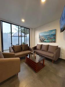 a living room with two couches and a table at FinlandHouse in Puerto López