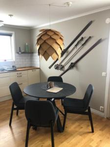 a table and chairs in a kitchen with hockey sticks on the wall at Gårdens Stugor - stugor för självhushåll in Klimpfjäll +2 photos