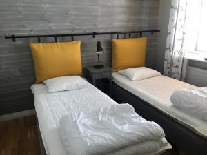 two beds sitting next to each other in a room at Gårdens Stugor - stugor för självhushåll in Klimpfjäll