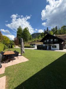 a lawn with a table and a house at ChaletFeeling im Salzkammergut in Strobl