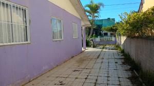 an alleyway between a purple building and a street at CasaZita in Passo De Torres