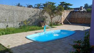 a pool with a water fountain in a yard at CasaZita in Passo De Torres
