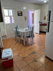 a kitchen with a table with chairs and a refrigerator at CasaZita in Passo De Torres