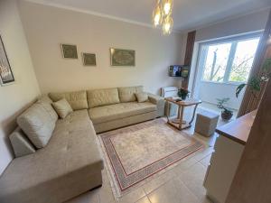 a living room with a couch and a table at Parkview Home in Korçë