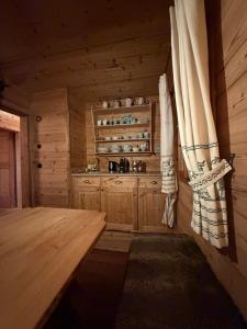 a kitchen in a wooden cabin with a wooden table at ChaletFeeling im Salzkammergut in Strobl