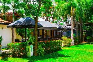 a house with an umbrella and some plants and trees at Hotel Green Garden PVT LTD in Trincomalee