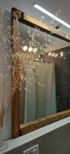 a mirror sitting on top of a shelf with a plant at Catia's Apartments, Clima, Mare&Spiaggia 700mt in Porto San Giorgio