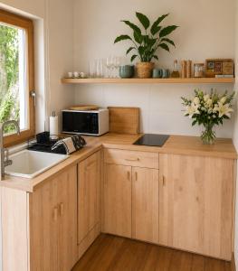 a kitchen with a sink and a microwave at BaLOVEon Birtok in Káptalantóti +23 photos