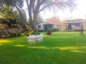 a table and chairs on a lawn in a yard at Log in At 118 Loghome in Meyerton +24 photos