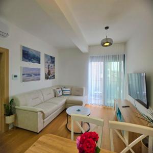 a living room with a couch and a table at Olive residence A8 in Petrovac na Moru