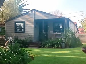a tiny house in a yard at Log in At 118 Loghome in Meyerton