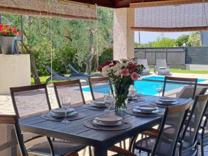 a black table with a vase of flowers on it at Villa Grace Felice in Fažana