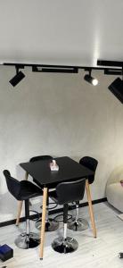 a black table with black chairs in a room at Mini House in Shahumyan