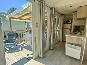 a kitchen and a patio with a table and a chair at De Pujol Greenchalets Argeles sur Mer in Argelès-sur-Mer