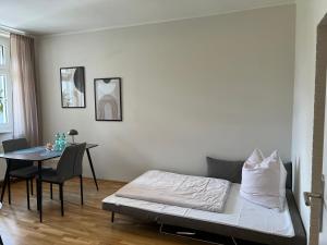 a living room with a bed and a table at Ruhrperle Apartment 2 Essen in Essen