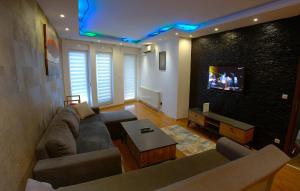 a living room with a couch and a tv at Prishtina Host in Prishtinë