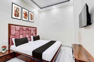 a bedroom with a bed and a flat screen tv at Hotel O BAL GOPAL in Delhi