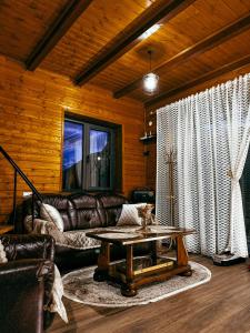 a living room with a leather couch and a table at Omenor Kazbegi in Kazbegi