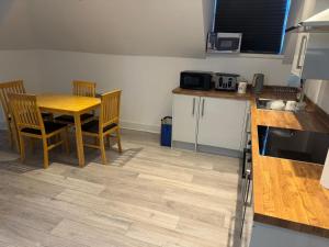 a kitchen with a table and chairs and a table and a counter at Epsom High Street Apartment 9 in Epsom