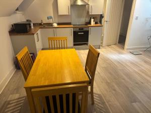 a kitchen with a wooden table and chairs at Epsom High Street Apartment 9 in Epsom