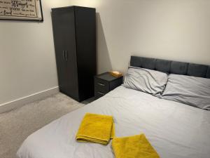 a bedroom with a bed with two towels on it at Epsom High Street Apartment 9 in Epsom