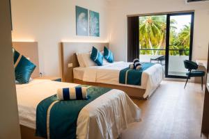 a hotel room with two beds and a balcony at Kashiveli Omadhoo in Omadhoo +49 photos