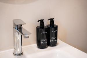 two black bottles sitting on top of a bathroom sink at Kashiveli Omadhoo in Omadhoo