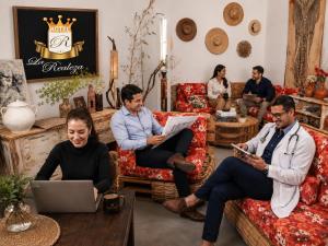 a group of men sitting in a living room with a laptop at Hotel La Realeza in Barbosa