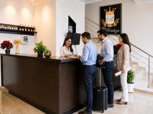 a group of people standing at a reception desk at Hotel La Realeza in Barbosa