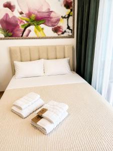 a bed with two towels on top of it at Blue Bay Studio in Bečići