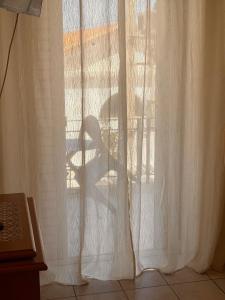 a shadow of a chair on a window at Port Breeze Apartments in Karlovasi +33 photos