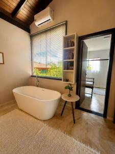 a bath tub in a bathroom with a window at Pariká Pousada in Alto Paraíso de Goiás +33 photos