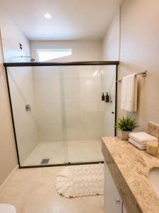a glass shower in a bathroom with a sink at Pariká Pousada in Alto Paraíso de Goiás