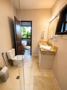 a bathroom with a toilet and a sink and a shower at Pariká Pousada in Alto Paraíso de Goiás