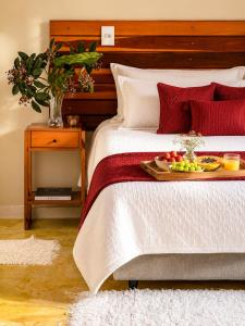 a bed with a tray of fruit on it at Pariká Pousada in Alto Paraíso de Goiás
