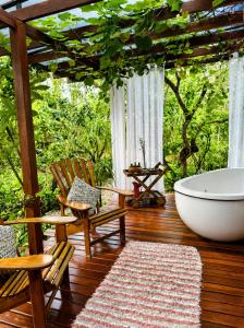 a bathroom with a tub and a chair on a deck at Pariká Pousada in Alto Paraíso de Goiás