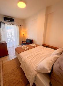 a bedroom with a large bed with two towels on it at Port Breeze Apartments in Karlovasi