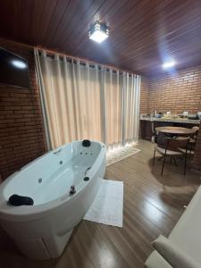 a bath tub in a room with a table and a dining room at Vivendas Canaã in Espera Feliz +55 photos