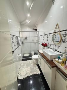a white bathroom with a sink and a toilet at Harmonia e Paz in São José dos Campos +26 photos