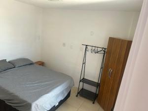a bedroom with a bed and a wooden cabinet at COBERTURA Duplex com Visao do Mar, Village das ondas in Piúma +41 photos