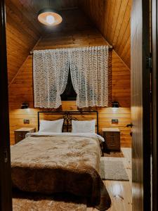 a bedroom with a bed in a wooden cabin at Omenor Kazbegi in Kazbegi