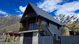 a black and white building with mountains in the background at Omenor Kazbegi in Kazbegi