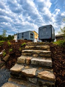 a camper and a trailer parked next to some rocks at Andělka maringotka in Humpolec