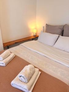 a bedroom with two beds with towels on the floor at Port Breeze Apartments in Karlovasi