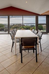 a white table and chairs in a room with windows at The View at Kurrara, American River in Muston