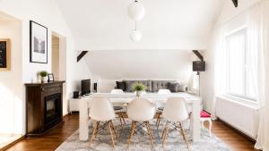 a white dining room with a table and chairs at Haus OS in Bischofshofen