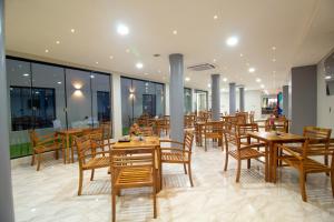 a restaurant with wooden tables and chairs and windows at Los Olivos Hotel in San Estanislao