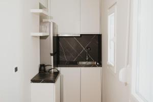 a kitchen with white cabinets and a sink at Shehu Skenderbeg Stay in Tirana
